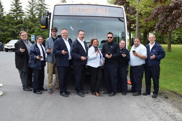 group of people standing in front of a bus