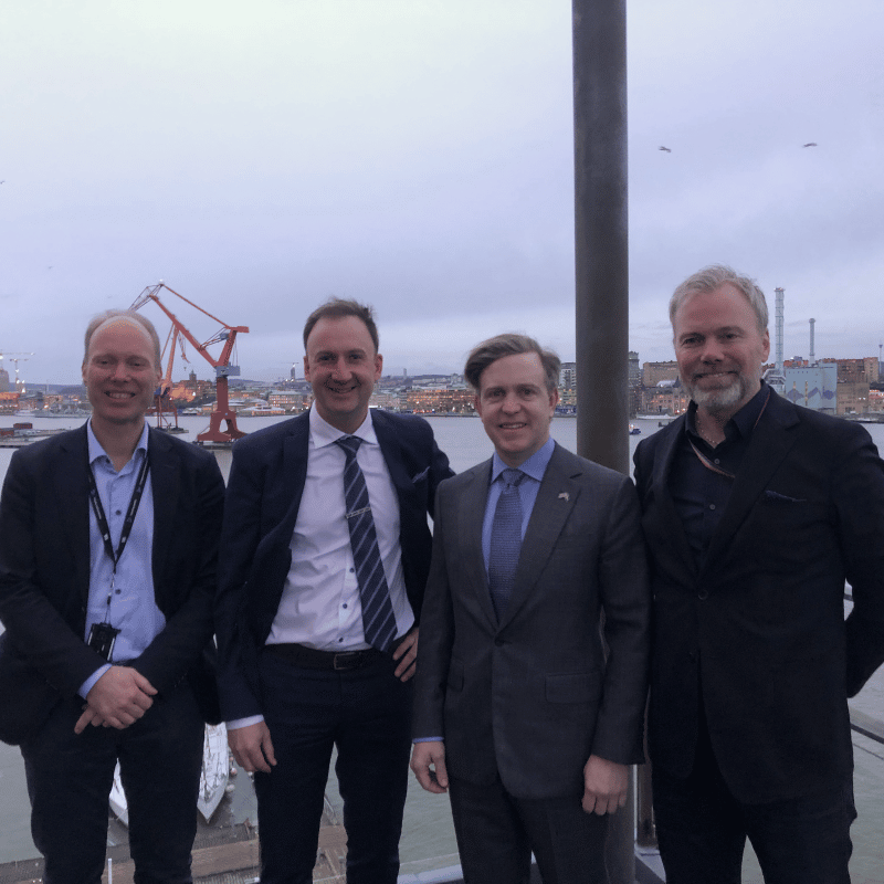 four men with city in background