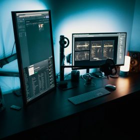 two computer screens on a desk