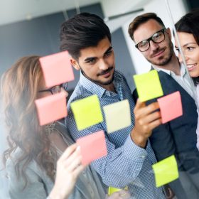 four people looking at post it,s